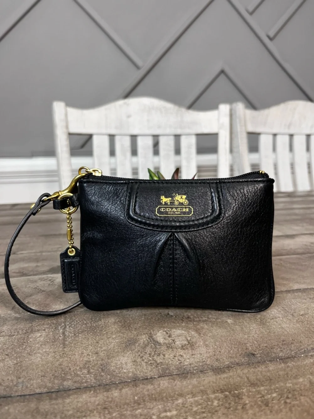 Madison black pebbled leather wristlet featuring gold-tone‎ hardware